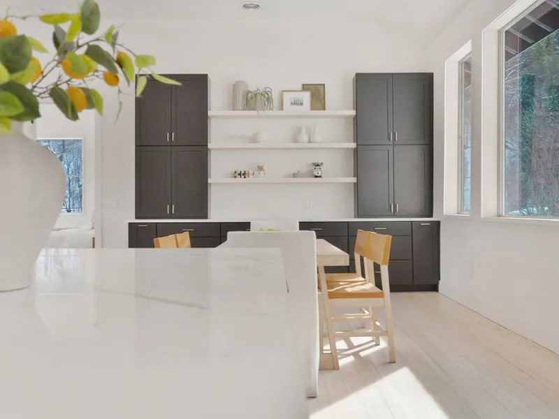 Built-in breakfast nook with a curved upholstered bench and warm wood cabinetry beside a bright window